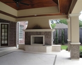 Outdoor fireplace with stone facing and covered patio