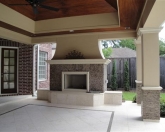 Outdoor fireplace with stone facing and covered patio